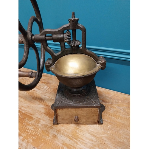 425 - Early 20th C. cast iron and brass wheel coffee grinder {50 cm H x 40 cm W x 34 cm D}.