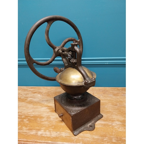 425 - Early 20th C. cast iron and brass wheel coffee grinder {50 cm H x 40 cm W x 34 cm D}.