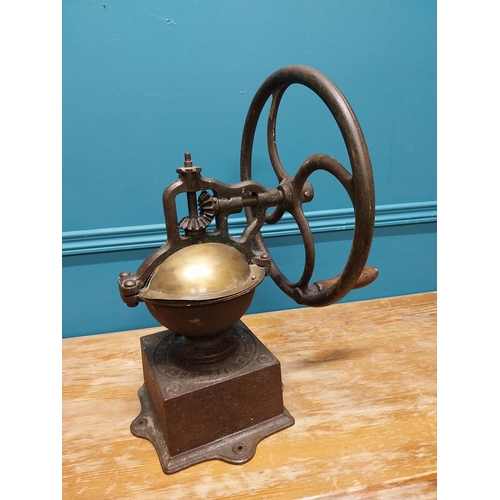 425 - Early 20th C. cast iron and brass wheel coffee grinder {50 cm H x 40 cm W x 34 cm D}.