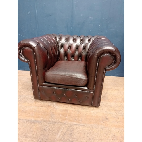 63 - Red leather deep buttoned tub chair raised on casters {H 72cm x W 100cm x D 85cm }.