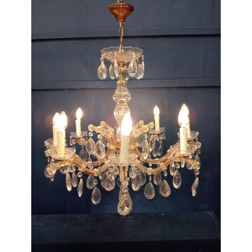 9 - Eight branch brass and crystal chandelier {H 90cm x Dia 70cm}.