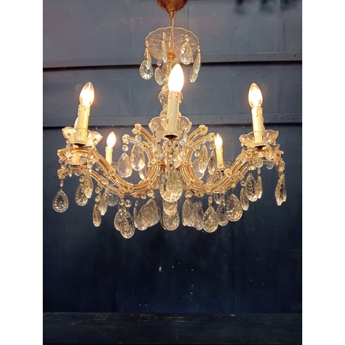 9 - Eight branch brass and crystal chandelier {H 90cm x Dia 70cm}.