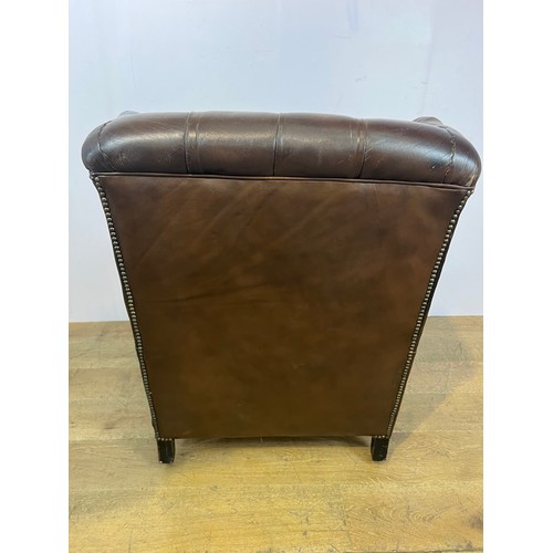 139 - Brown leather deep buttoned Chesterfield wingback armchair raised on brass castors  {H 96cm x W 94cm... 