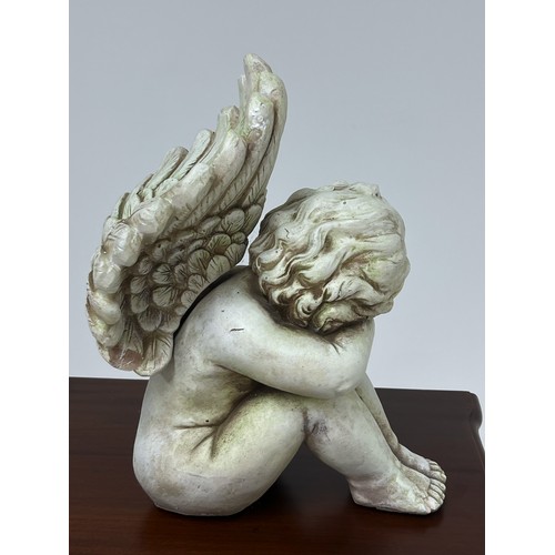 188 - Resin figure of a cherub {H 36cm x W 20cm x D 30cm }.