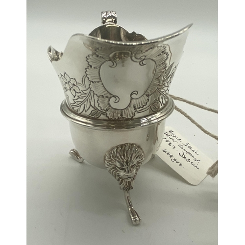 1354 - Pair of Irish silver milk jugs with hand chased florals to the top rim with an open monogram cartouc... 