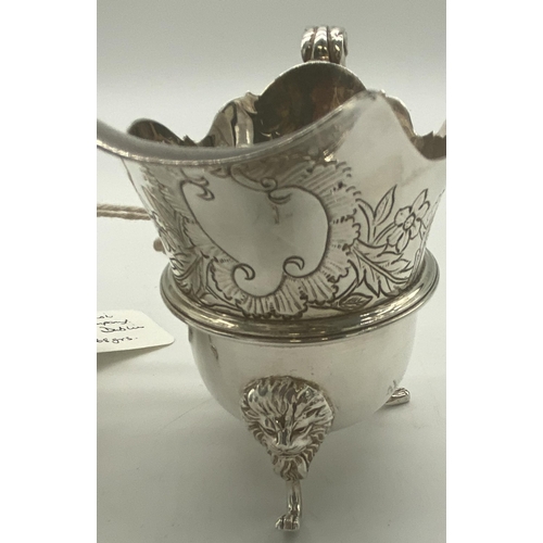 1354 - Pair of Irish silver milk jugs with hand chased florals to the top rim with an open monogram cartouc... 