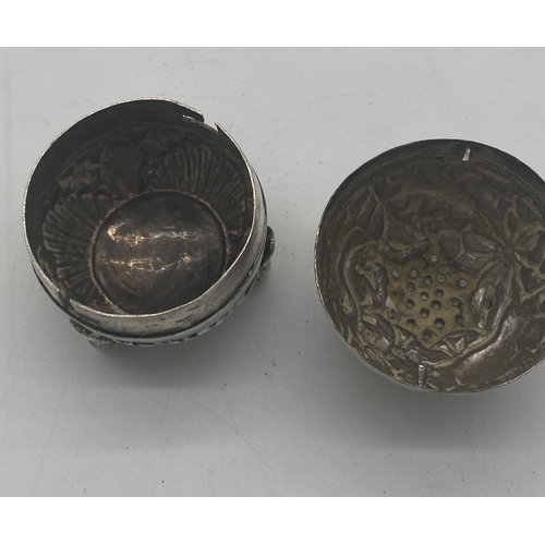 1421 - White metal pepper pot decorated with foliage, elephants and dogs. Wt: 32grs. { 5cm H X 4cm Dia }.