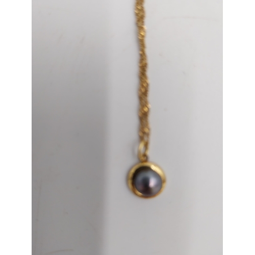 1478 - 14 carat gold { stamped 585 } chain and pendant, the pedant inset with a grey coloured stone.