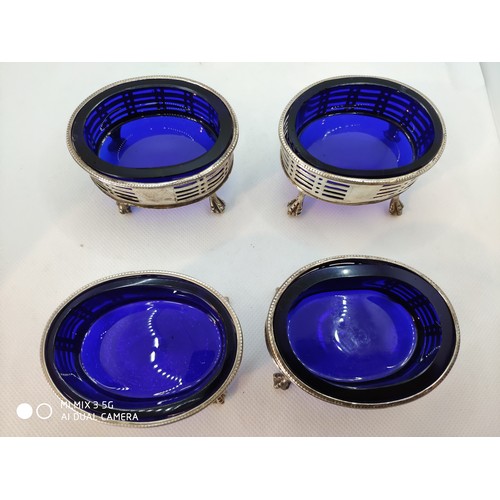 1395 - Set of four Irish Georgian silver salts with Bristol blue liners, the frames of oval form with pierc... 