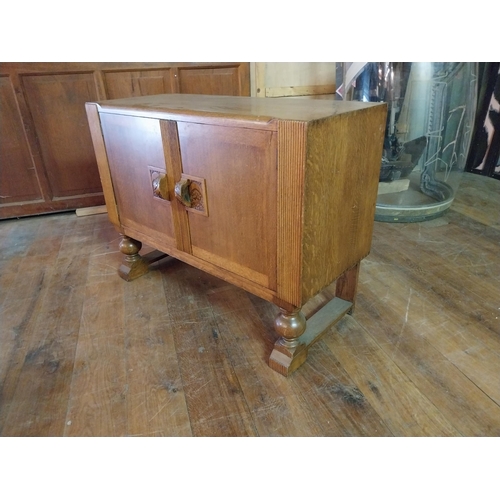 153 - Art Deco oak side board with two panelled doors and fitted interior raised on turned legs {90 cm H x... 