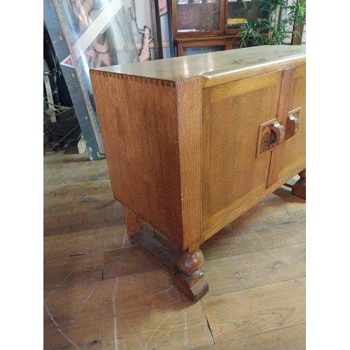 153 - Art Deco oak side board with two panelled doors and fitted interior raised on turned legs {90 cm H x... 