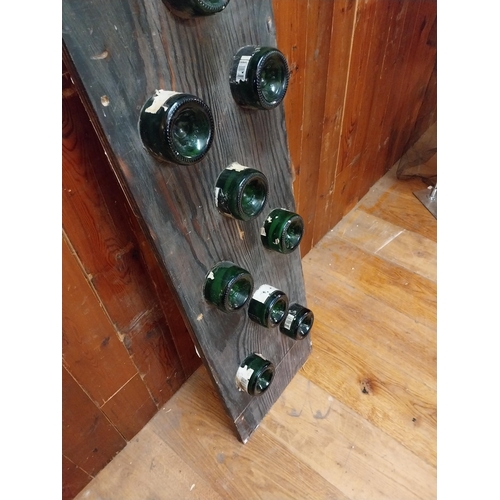 282 - Champagne bottles mounted on oak plaque {160 cm H x 35 cm W x 10 cm D}.