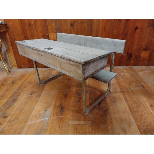 381 - 1950s oak and cast iron double school desk {63 cm H x 102 cm W x 63 cm D}.