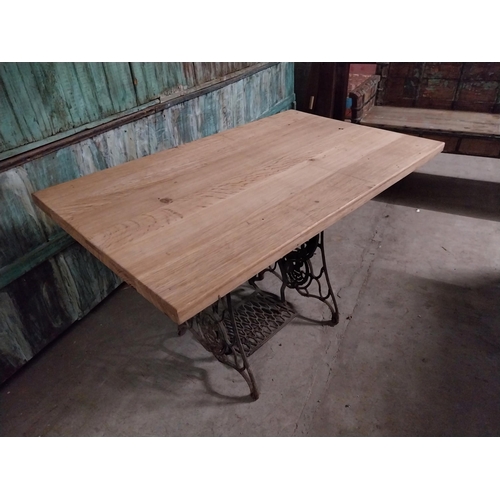 416 - Good quality oak pub table with cast iron singer sewing machine base {74 cm H x 120 cm W x 70 cm D}.