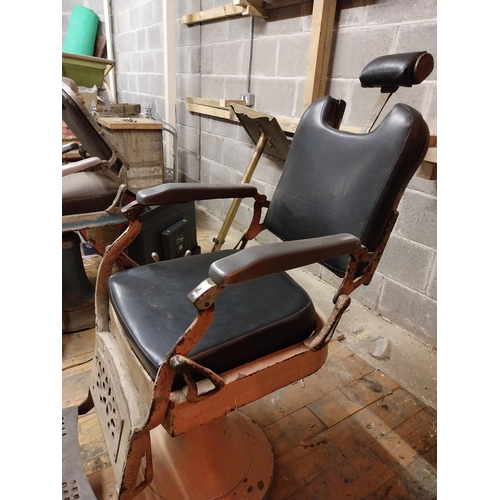 617 - Early 20th C. cast iron and upholstered vinyl barbers chair{115 cm H x 60 cm W x 100 cm D}.