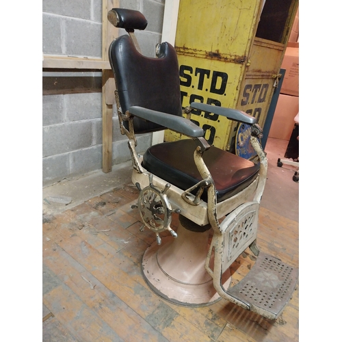 617 - Early 20th C. cast iron and upholstered vinyl barbers chair{115 cm H x 60 cm W x 100 cm D}.