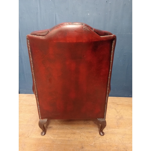 305 - Leather deep buttoned wingback armchair {H 106cm x W 78cm x D 74cm }.