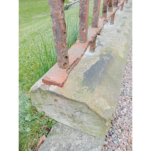 75 - Patio blacksmith wrought iron railings raised on sandstone base {H 56cm x L 630cm x D 23cm}.