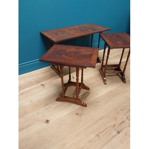 357 - Mahogany nest of three tables raised on turned columns and platform feet {48 cm H x 76 cm W x 41 cm ... 