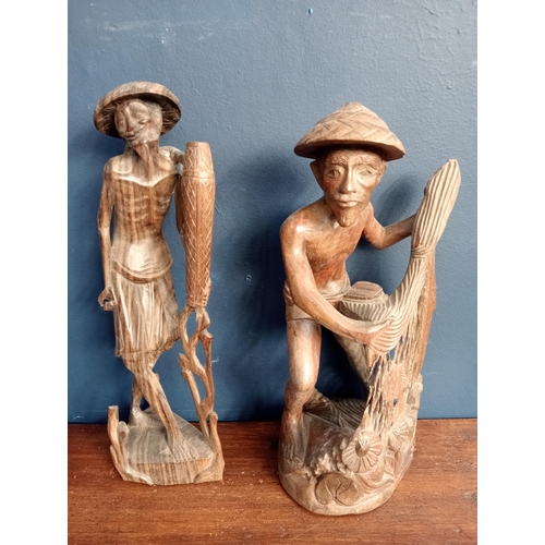 413 - Pair of Balinese hand carved  wooden sculptures of fishermen {H 25cm x W 12cm x D 9cm }.