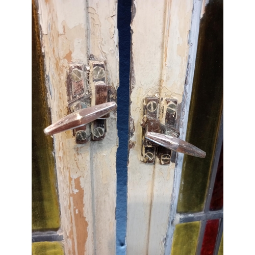 428 - Pair of cast iron leaded stain glass windows with brass handles {Each H 128cm x W 58cm x D 3cm}.