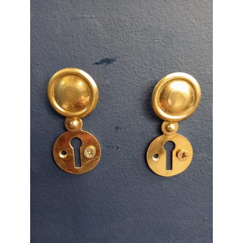 431 - Pair of covered Victorian brass escutcheons. {D 3cm}.