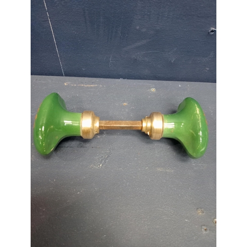 443 - Pair of green oval ceramic and brass door knobs. {H 4cm x W 6cm x D 14cm}.