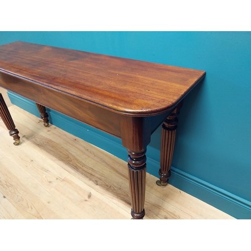 497 - Good quality William IV mahogany side table raised on reeded legs and brass castors {74 cm H x 138 c... 