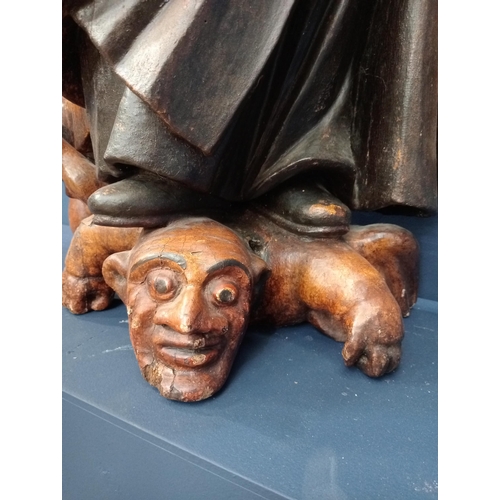 564 - Solid wooden 18th C. religious figure of St Anthony conquering the demons shown under his feet {H 88... 