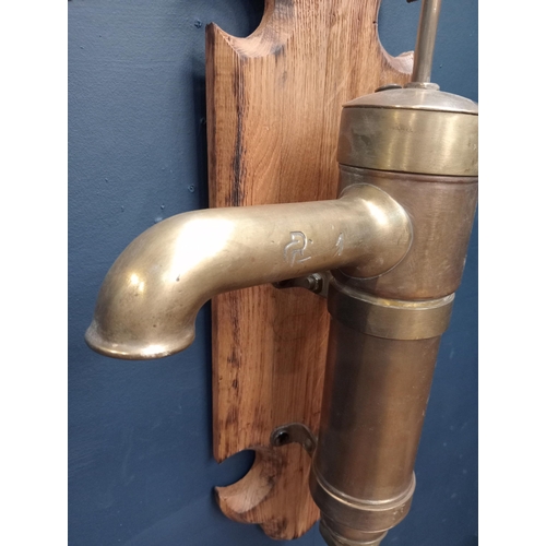 715 - Brass wall  pump on oak plaque {H 60cm x W 36cm x D 45cm}.