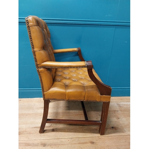 102 - Mahogany deep buttoned leather upholstered Gainsborough armchair with upholstered arms terminating i... 