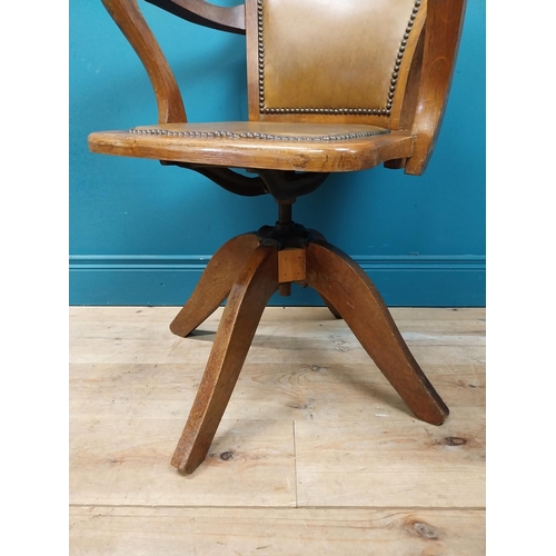 106 - Early 20th C. oak and leather upholstered office chair. {86 cm H x 60 cm W x 53 cm D}.