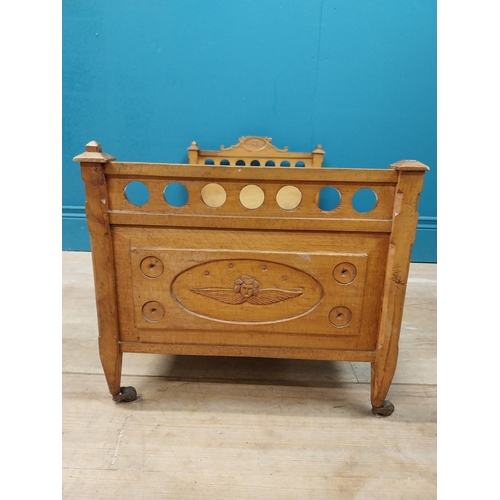 126 - Early 20th C. oak dog bed with side panels decorated with cherubs on tapered feet and brass casters.... 