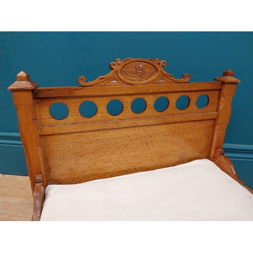 126 - Early 20th C. oak dog bed with side panels decorated with cherubs on tapered feet and brass casters.... 