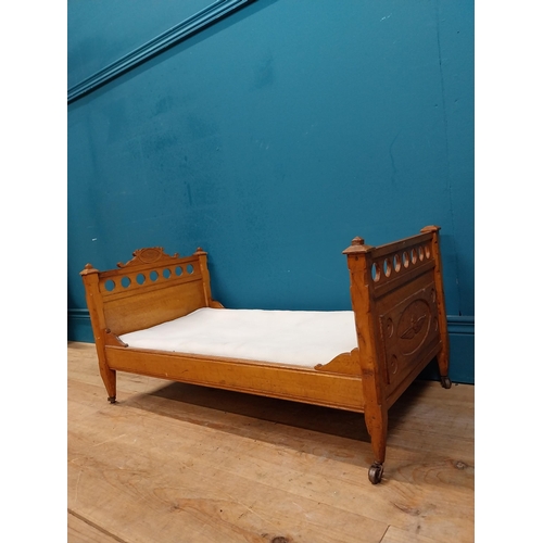 126 - Early 20th C. oak dog bed with side panels decorated with cherubs on tapered feet and brass casters.... 