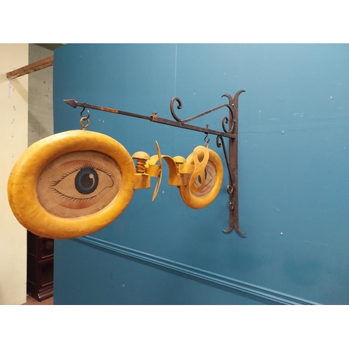 13 - Painted metal hanging Optician's sign with bracket. {69 cm H x 97 cm W x 17 cm D}.