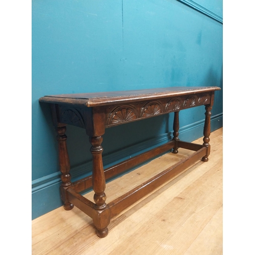 138 - Early 20th C. oak stool with shell motif in frieze on four turned legs. {35 cm H x 92 cm W x 31 cm D... 