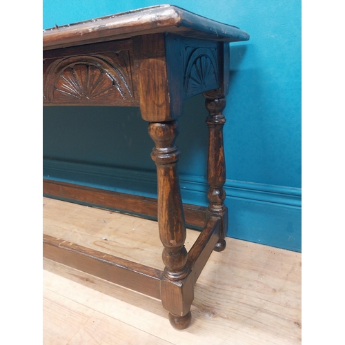 138 - Early 20th C. oak stool with shell motif in frieze on four turned legs. {35 cm H x 92 cm W x 31 cm D... 