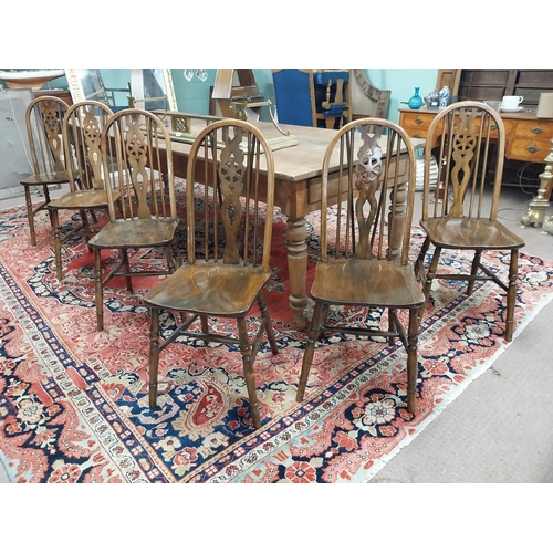 192 - Set of six 1950s pine wheel back Kitchen chairs raised on turned legs and single stretcher {96 cm H ... 