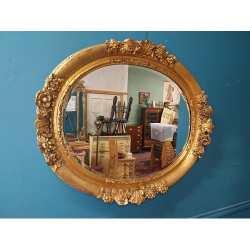 311 - 19th C. giltwood oval hall mirror surmounted with leaves and flowers. {81 cm H x 96 cm W}.