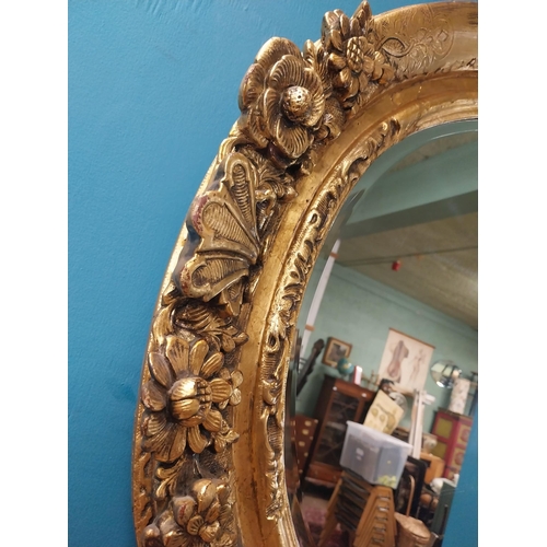 311 - 19th C. giltwood oval hall mirror surmounted with leaves and flowers. {81 cm H x 96 cm W}.