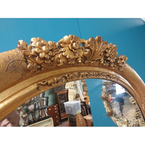 311 - 19th C. giltwood oval hall mirror surmounted with leaves and flowers. {81 cm H x 96 cm W}.