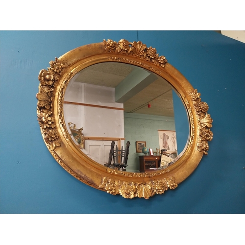 311 - 19th C. giltwood oval hall mirror surmounted with leaves and flowers. {81 cm H x 96 cm W}.