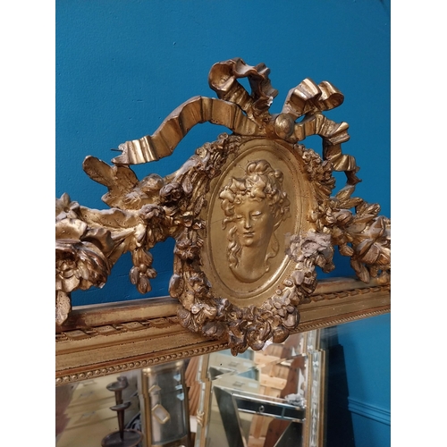 330 - 19th C. French gilt mirror with floral decoration surmounted with female mask and bows. {168 cm H x ... 