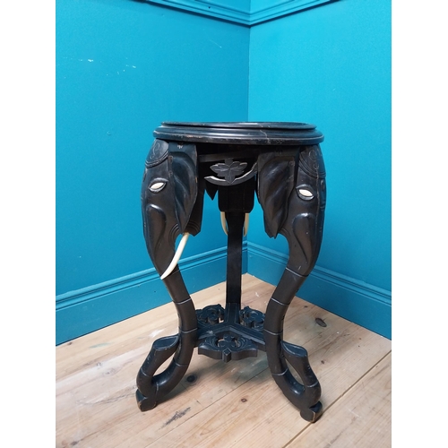 364 - 10th C. ebonised lamp table with elephant decoration. {64 cm H x 40 cm Dia.}.