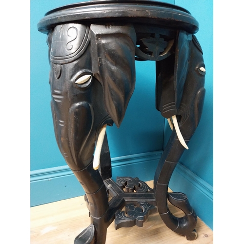 364 - 10th C. ebonised lamp table with elephant decoration. {64 cm H x 40 cm Dia.}.