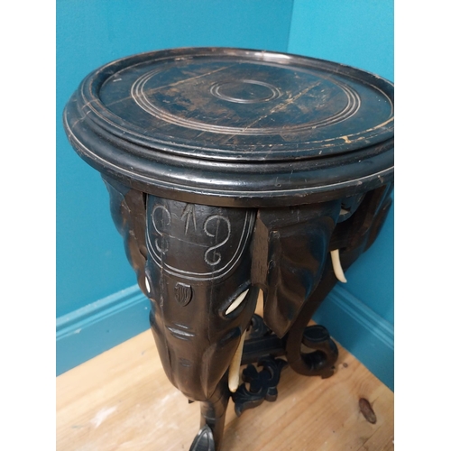 364 - 10th C. ebonised lamp table with elephant decoration. {64 cm H x 40 cm Dia.}.