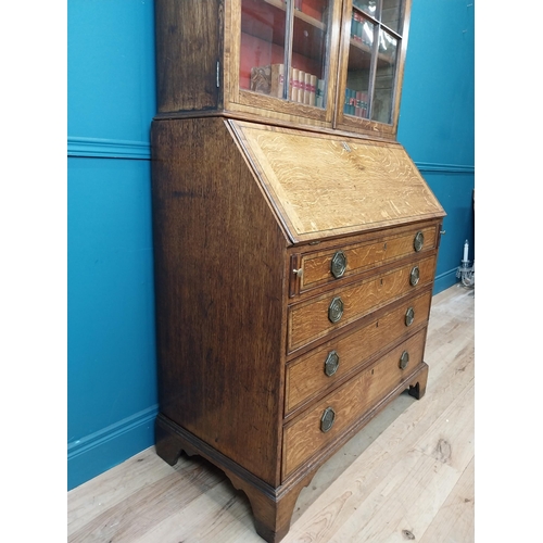 397 - Georgian oak bureau bookcase with fitted red velvet interior on bracket feet above two glazed doors.... 