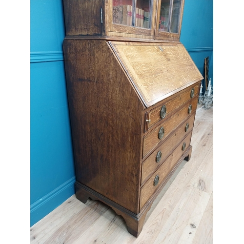 397 - Georgian oak bureau bookcase with fitted red velvet interior on bracket feet above two glazed doors.... 