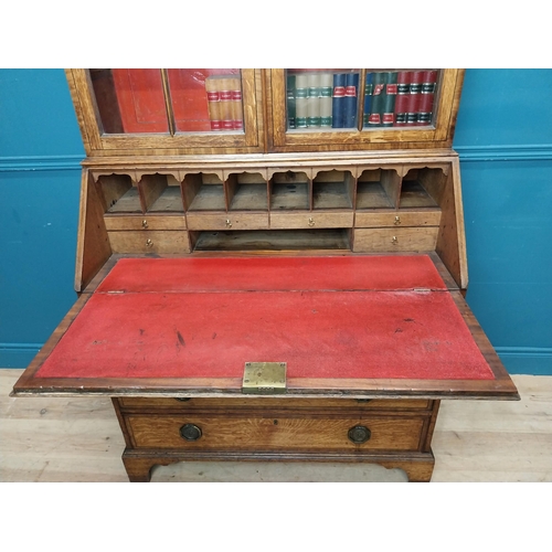 397 - Georgian oak bureau bookcase with fitted red velvet interior on bracket feet above two glazed doors.... 